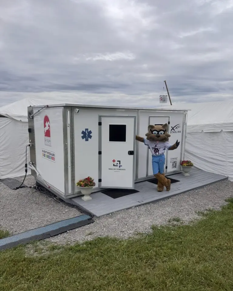 White modular shelter on a rooftop with a mascot figure nearby.